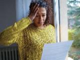 Une femme regarde un document avec inquitude.